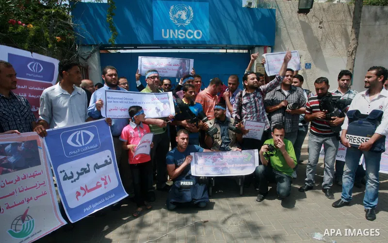 Palestinian journalists and photographers take part in a protest in support with the photographer, Mohammed Osman, in front of UNRWA headquarters in Gaza city on May 16, 2012. Photo by Naaman Omar
