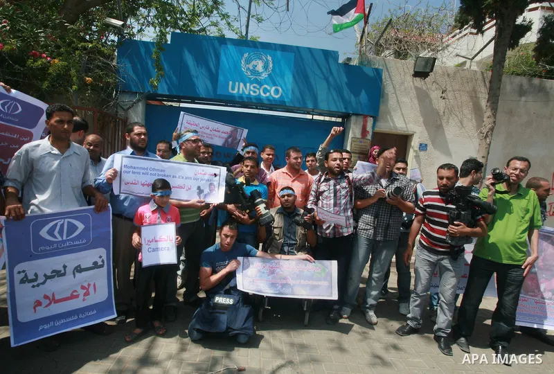 Palestinian journalists and photographers take part in a protest in support with the photographer, Mohammed Osman, in front of UNRWA headquarters in Gaza city on May 16, 2012. Photo by Naaman Omar