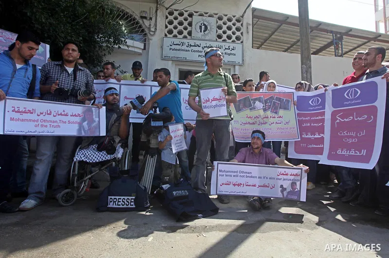 Palestinian journalists and photographers take part in a protest in support with the photographer, Mohammed Osman, in front of Palestinian Centre for Human Rights in Gaza city on May 16, 2012. Photo by Ashraf Amra