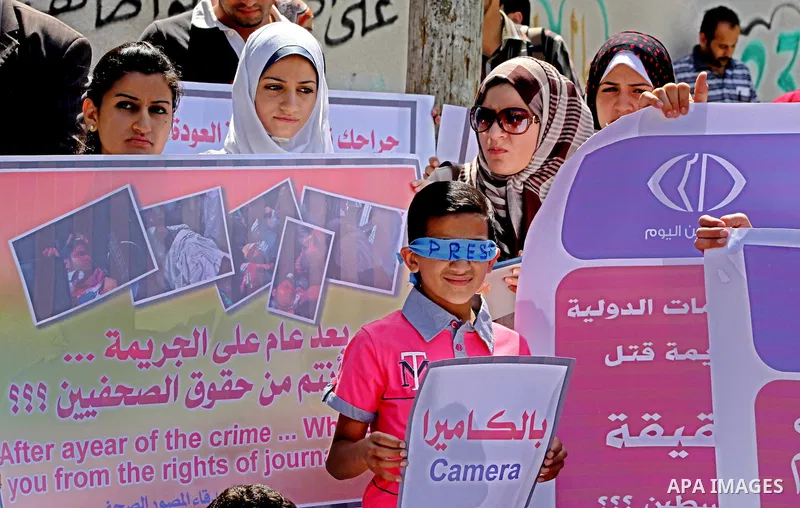 Palestinian journalists and photographers take part in a protest in support with the photographer, Mohammed Osman, in front of UNRWA headquarters in Gaza city on May 16, 2012. Photo by Ashraf Amra