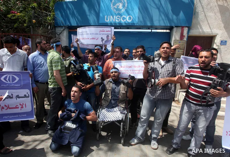 Palestinian journalists and photographers take part in a protest in support with the photographer, Mohammed Osman, in front of UNRWA headquarters in Gaza city on May 16, 2012. Photo by Ashraf Amra