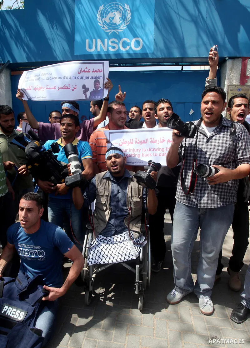 Palestinian journalists and photographers take part in a protest in support with the photographer, Mohammed Osman, in front of UNRWA headquarters in Gaza city on May 16, 2012. Photo by Ashraf Amra