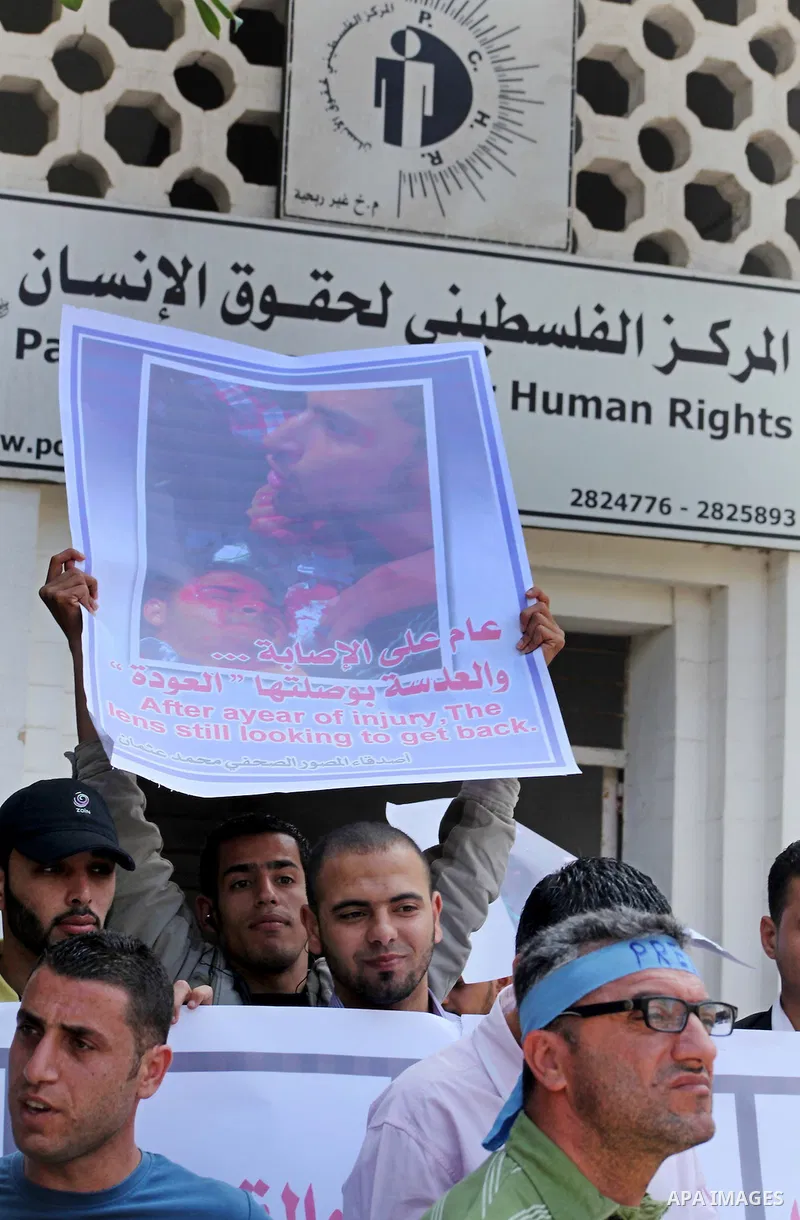 Palestinian journalists and photographers take part in a protest in support with the photographer, Mohammed Osman, in front of Palestinian Centre for Human Rights in Gaza city on May 16, 2012. Photo by Ashraf Amra