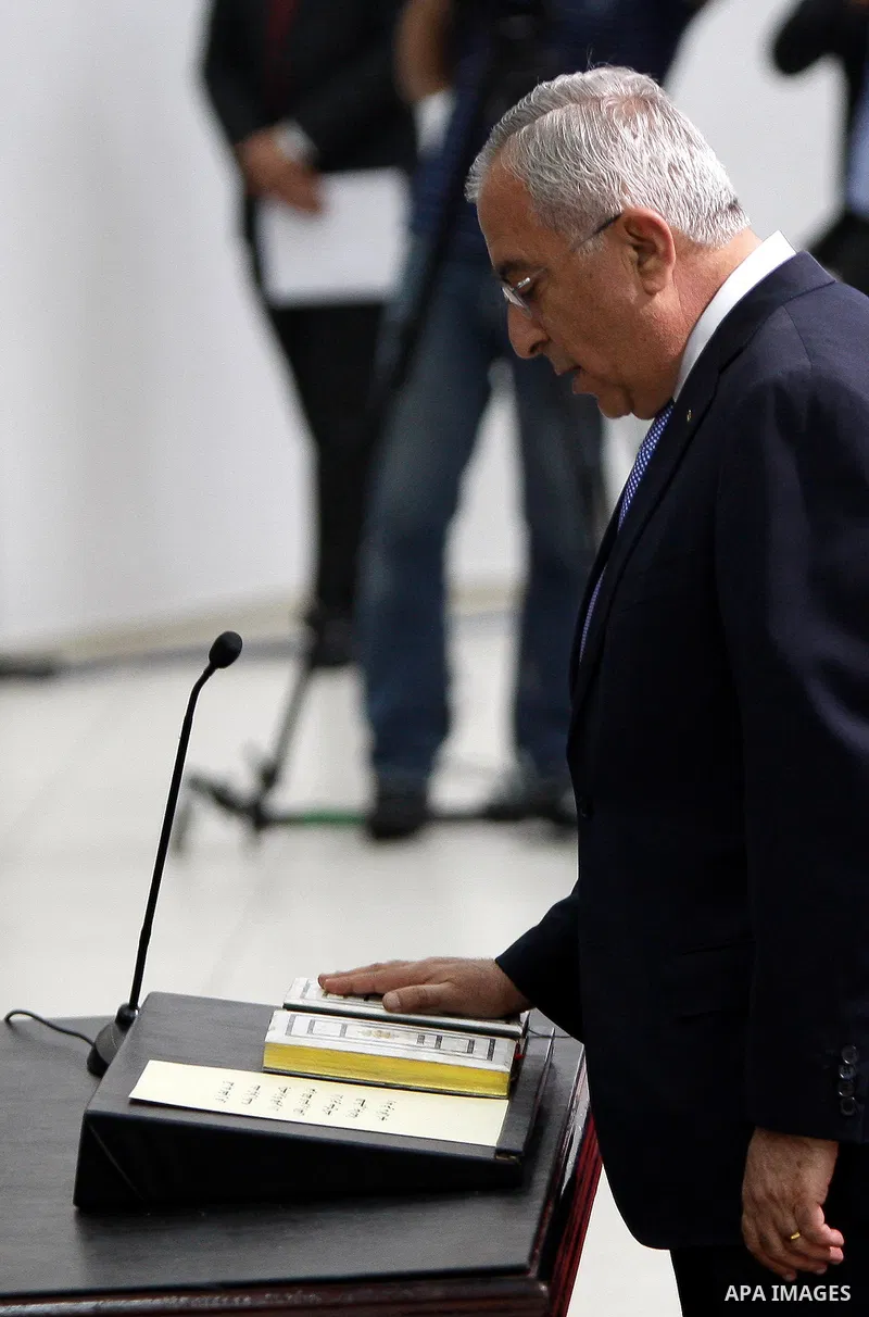 Palestinian National Authority President Mahmoud Abbas and his Prime Minister Salam Fayyad, receive the new government Ministers during the swearing in ceremony of the new cabinet, at Abbas's headquarters in the West Ban...