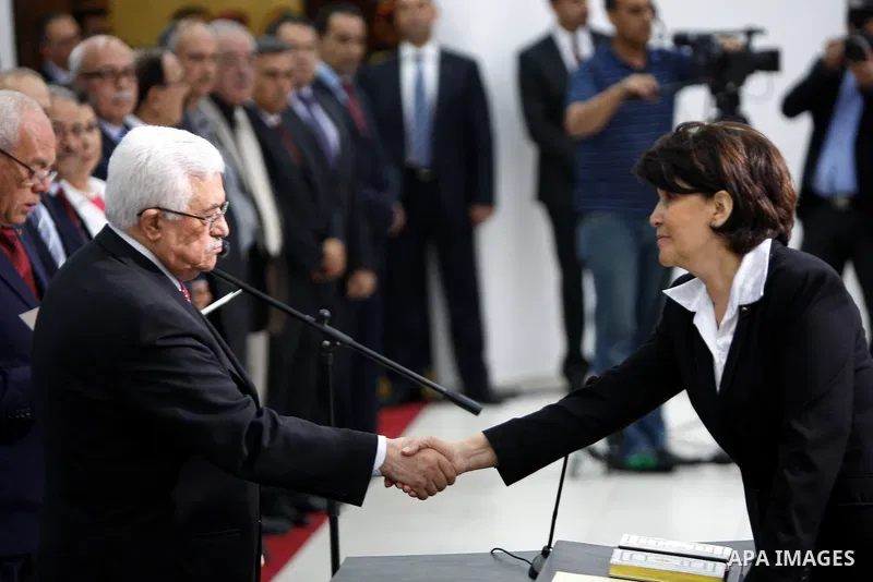 Palestinian National Authority President Mahmoud Abbas and his Prime Minister Salam Fayyad, receive the new government Ministers during the swearing in ceremony of the new cabinet, at Abbas's headquarters in the West Ban...