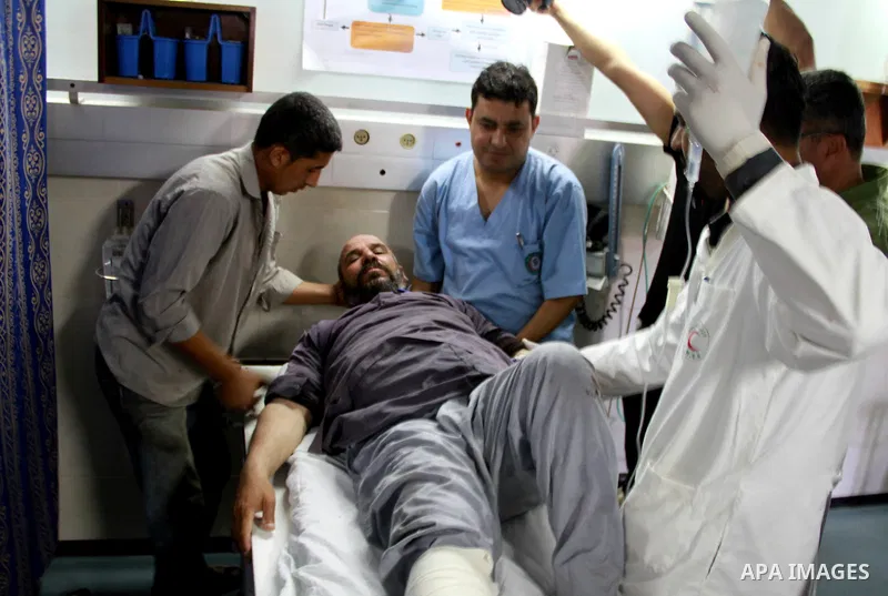 Palestinian medics receive a wounded man for treatment at a hospital in Gaza City on May 17, 2012, following Israeli shelling into the Gaza Strip in which seven people were wounded, two of them in critical condition, nea...
