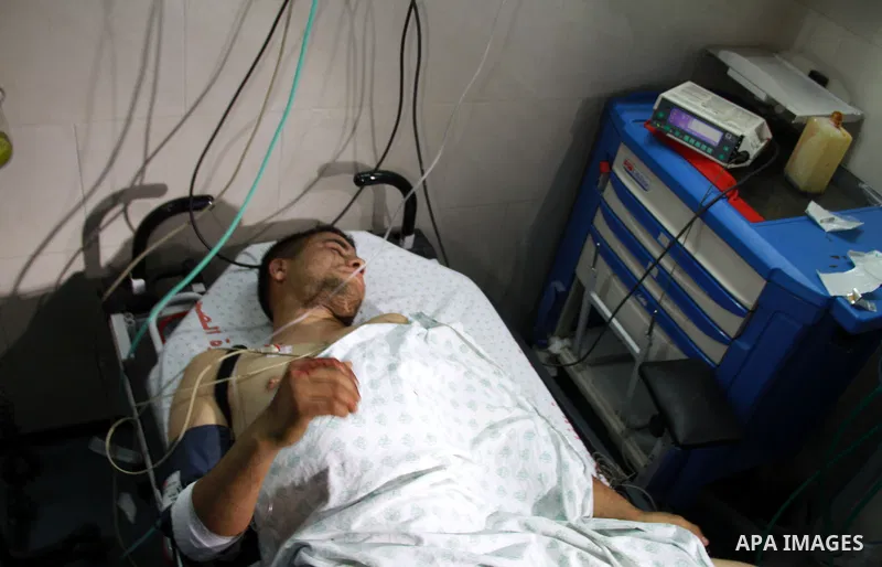 Palestinian medics receive a wounded man for treatment at a hospital in Gaza City on May 17, 2012, following Israeli shelling into the Gaza Strip in which seven people were wounded, two of them in critical condition, nea...