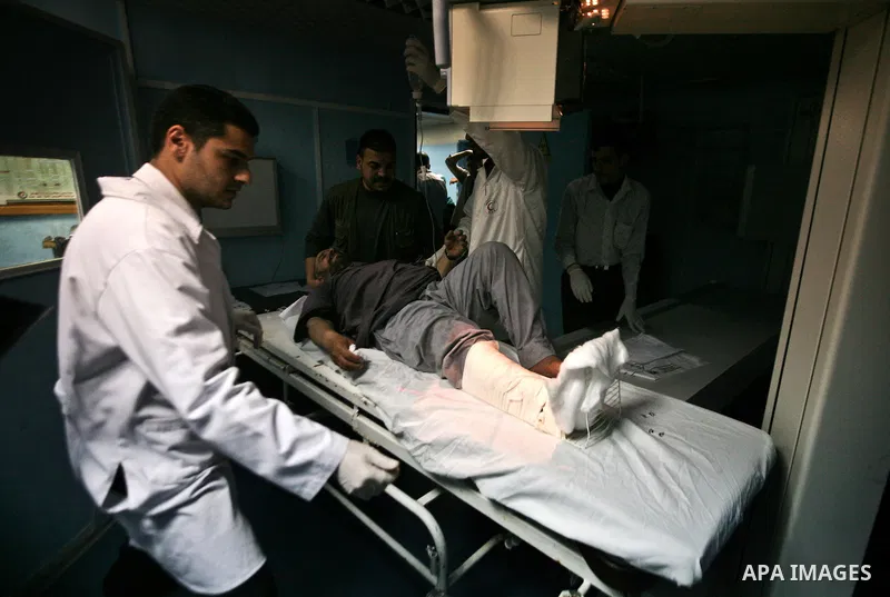 Palestinian medics receive a wounded man for treatment at a hospital in Gaza City on May 17, 2012, following Israeli shelling into the Gaza Strip in which seven people were wounded, two of them in critical condition, nea...