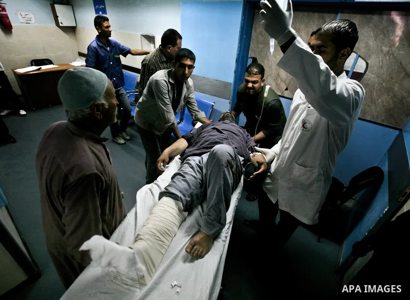 Palestinian medics receive a wounded man for treatment at a hospital in Gaza City on May 17, 2012, following Israeli shelling into the Gaza Strip in which seven people were wounded, two of them in critical condition, nea...