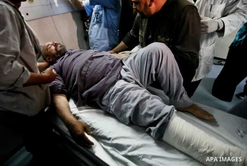 Palestinian medics receive a wounded man for treatment at a hospital in Gaza City on May 17, 2012, following Israeli shelling into the Gaza Strip in which seven people were wounded, two of them in critical condition, nea...