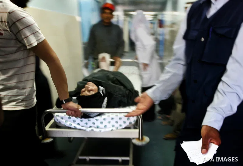 Palestinian medics receive a wounded man for treatment at a hospital in Gaza City on May 17, 2012, following Israeli shelling into the Gaza Strip in which seven people were wounded, two of them in critical condition, nea...