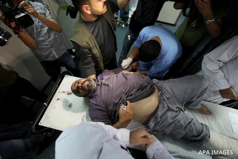 Palestinian medics receive a wounded man for treatment at a hospital in Gaza City on May 17, 2012, following Israeli shelling into the Gaza Strip in which seven people were wounded, two of them in critical condition, nea...