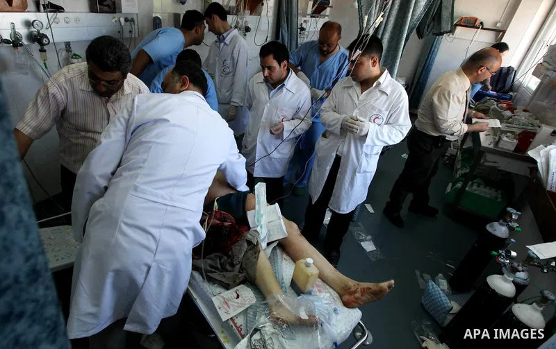 Palestinian medics receive a wounded man for treatment at a hospital in Gaza City on May 17, 2012, following Israeli shelling into the Gaza Strip in which seven people were wounded, two of them in critical condition, nea...