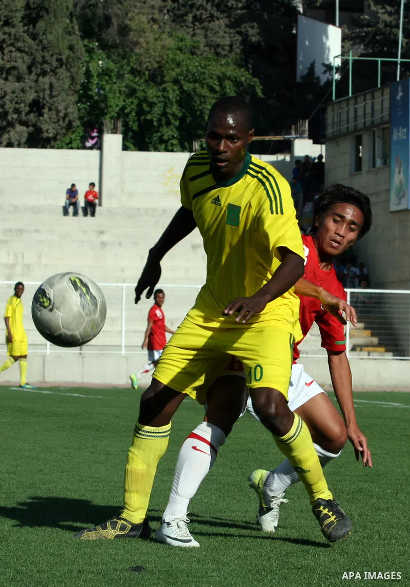 Mauritanian and Indonesian footballers fight for possession during a football match. Mauritanian and Indonesian footballers face-off during the Nakba Championship in the West Bank city of Nablus, on May 17, 2012. Nakba f...