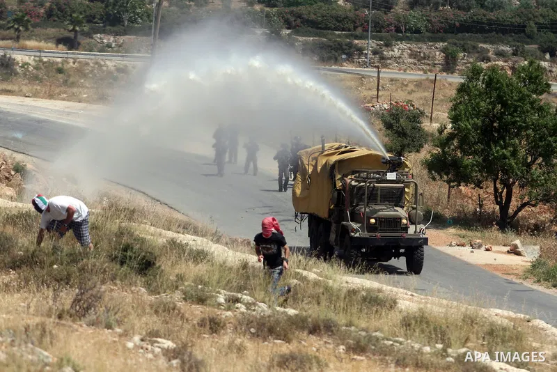 Israeli truck spray foul smelling water towards Palestinian protesters during a weekly demonstration in the West Bank, village of Nabi Saleh near Ramallah on Friday, May 18, 2012. Photo by Issam Rimawi