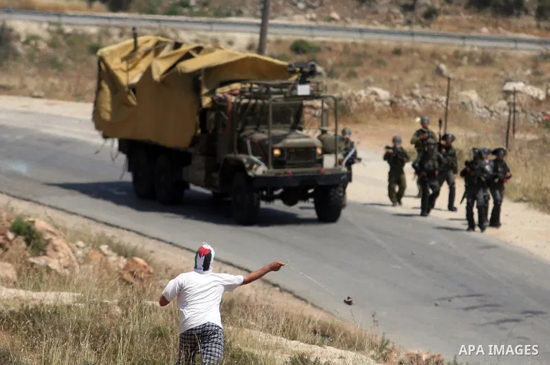Palestinian protesters throw stones towards Israeli border police during a weekly demonstration in the West Bank, village of Nabi Saleh near Ramallah on Friday, May 18, 2012. Photo by Issam Rimawi