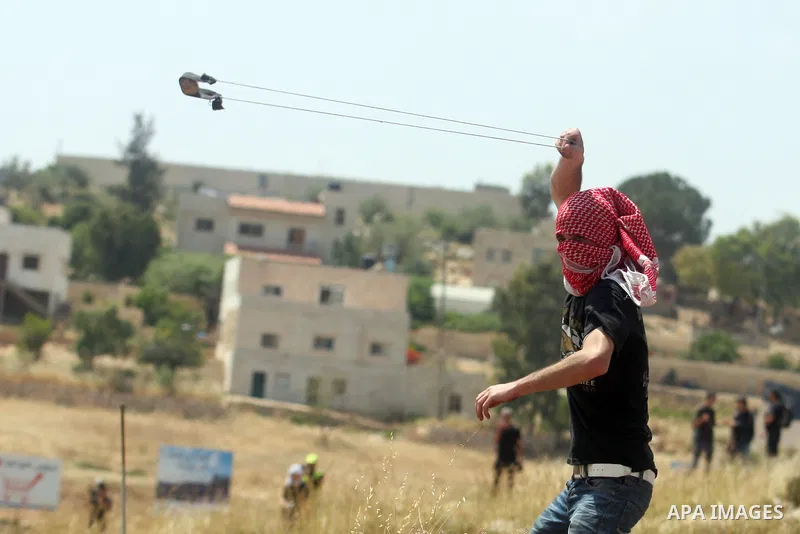 Palestinian protesters throw stones towards Israeli border police during a weekly demonstration in the West Bank, village of Nabi Saleh near Ramallah on Friday, May 18, 2012. Photo by Issam Rimawi