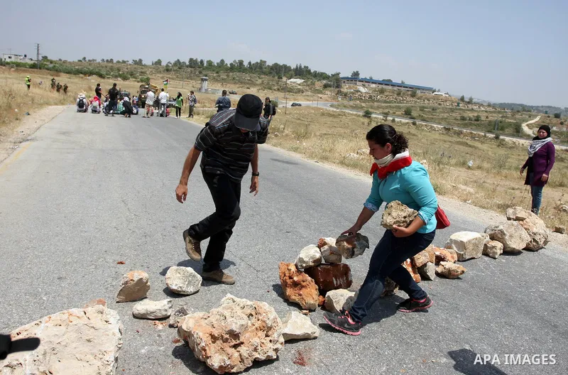 Palestinian protesters throw stones towards Israeli border police during a weekly demonstration in the West Bank, village of Nabi Saleh near Ramallah on Friday, May 18, 2012. Photo by Issam Rimawi