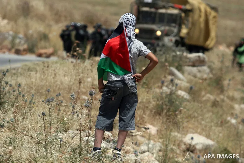 Palestinian protesters throw stones towards Israeli border police during a weekly demonstration in the West Bank, village of Nabi Saleh near Ramallah on Friday, May 18, 2012. Photo by Issam Rimawi