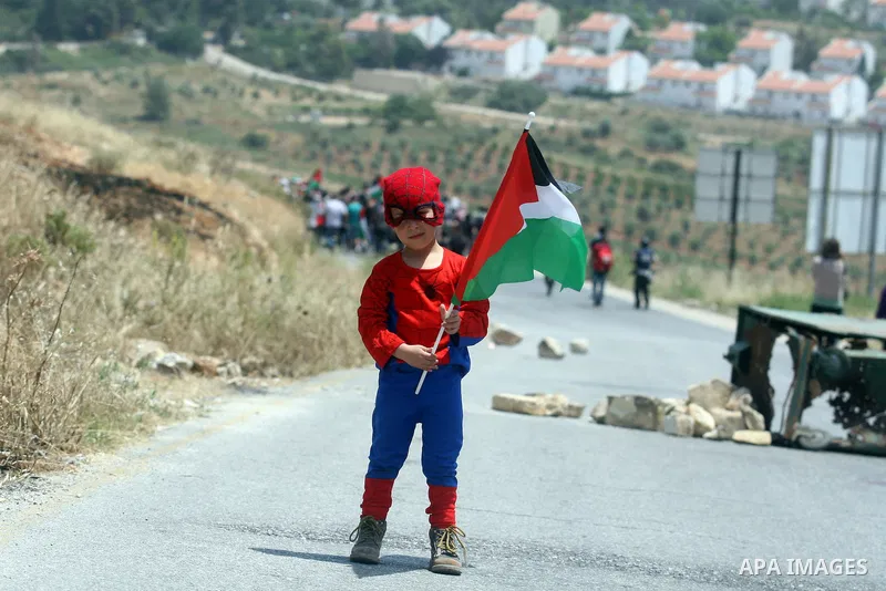 Palestinian child holds up national flag during a weekly demonstration in the West Bank, village of Nabi Saleh near Ramallah on Friday, May 18, 2012. Photo by Issam Rimawi