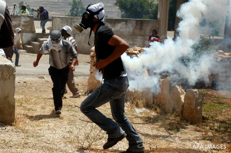 Palestinian Protester returns a teargas towards Israeli soldiers during clashes in the northern West Bank village of Kufr Qaddum, near the Jewish settlement of Kdumim, Friday, May 18, 2012. Photo by Wagdi Eshtayah