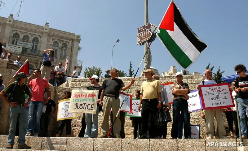 Palestinian and foreign activists hold Palestinian flags and slogans outside Damascus gate in Jerusalem's Old City, during a protest against land confiscation in the neighborhood of Sheikh Jarrah in the east Jerusalem on...