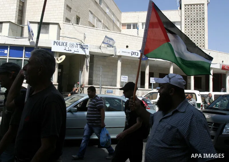 Palestinian and foreign activists hold Palestinian flags and slogans outside Damascus gate in Jerusalem's Old City, during a protest against land confiscation in the neighborhood of Sheikh Jarrah in the east Jerusalem on...