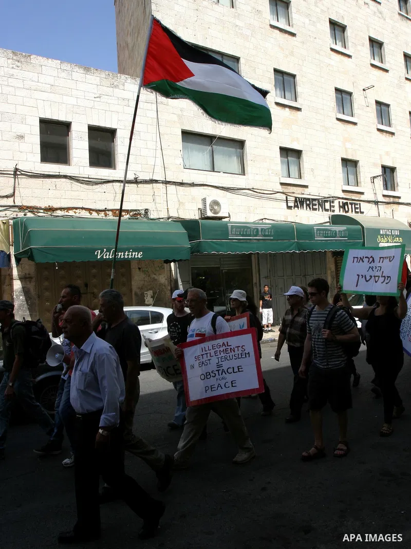 Palestinian and foreign activists hold Palestinian flags and slogans outside Damascus gate in Jerusalem's Old City, during a protest against land confiscation in the neighborhood of Sheikh Jarrah in the east Jerusalem on...