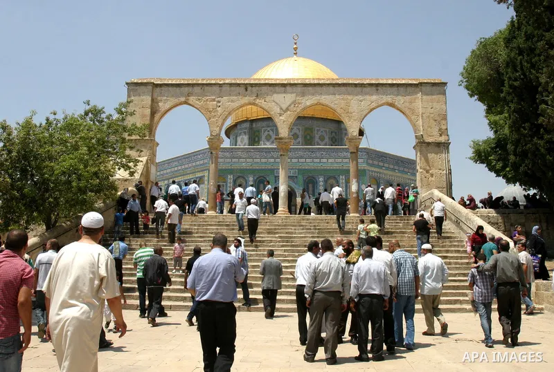 Palestinians walk in front of the Dome of Rock mosque during Friday prayers, in the Al Aqsa Mosque compound, in Jerusalem's old city on May 18, 2012. Photo by Mahfouz Abu Turk