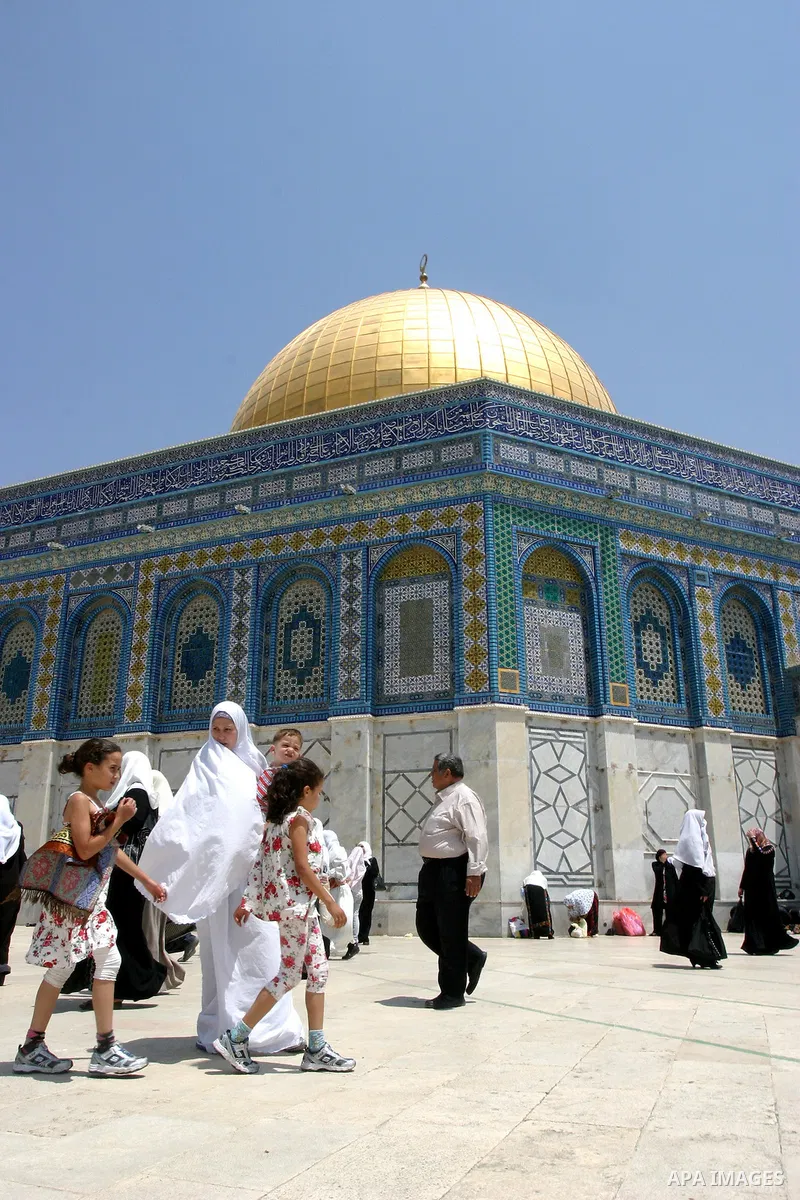 Palestinians walk in front of the Dome of Rock mosque during Friday prayers, in the Al Aqsa Mosque compound, in Jerusalem's old city on May 18, 2012. Photo by Mahfouz Abu Turk