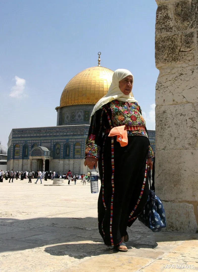 Palestinian woman walks in front of the Dome of Rock mosque during Friday prayers, in the Al Aqsa Mosque compound, in Jerusalem's old city on May 18, 2012. Photo by Mahfouz Abu Turk