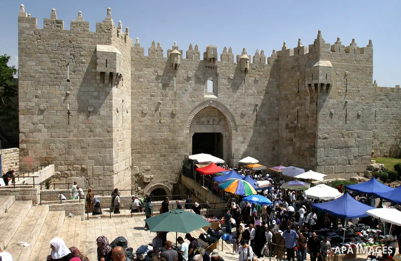 Palestinians walk in front of the Dome of Rock mosque during Friday prayers, in the Al Aqsa Mosque compound, in Jerusalem's old city on May 18, 2012. Photo by Mahfouz Abu Turk
