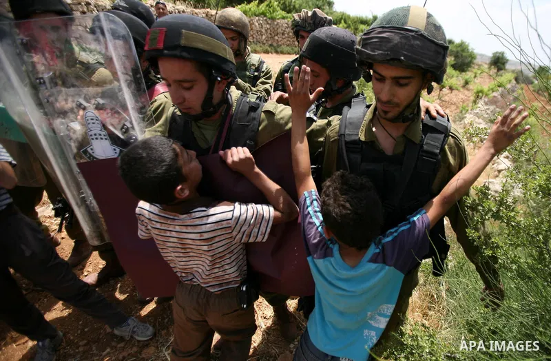 Palestinians wave their national flag during a demonstration a protest in Beit Amer village, north of the West Bank town of Hebron, on May 19, 2012 where Israeli soldiers tried to evacuate demonstrators by force and arre...