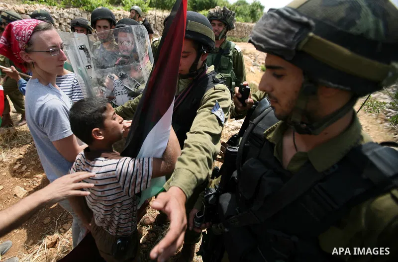 Palestinians wave their national flag during a demonstration a protest in Beit Amer village, north of the West Bank town of Hebron, on May 19, 2012 where Israeli soldiers tried to evacuate demonstrators by force and arre...