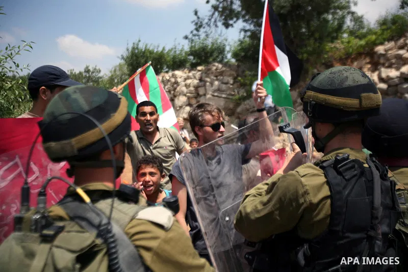 Palestinians wave their national flag during a demonstration a protest in Beit Amer village, north of the West Bank town of Hebron, on May 19, 2012 where Israeli soldiers tried to evacuate demonstrators by force and arre...
