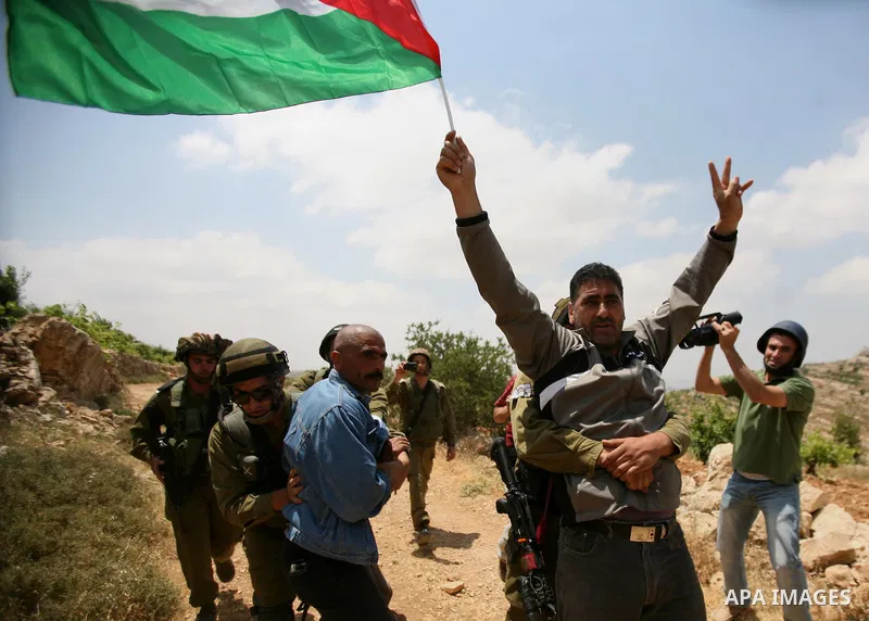 Palestinians wave their national flag during a demonstration a protest in Beit Amer village, north of the West Bank town of Hebron, on May 19, 2012 where Israeli soldiers tried to evacuate demonstrators by force and arre...