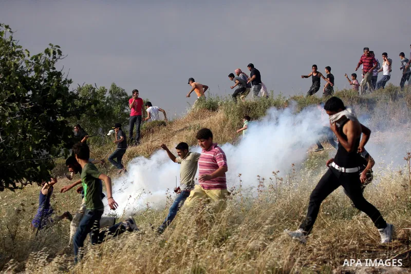 Israeli Soldiers fire tear gas toward Palestinians from the village of Asira al-Qibiliya during clashes with Israeli settlers from the Jewish settlement of Yitzhar, south of the northern West Bank city of Nablus on May 1...