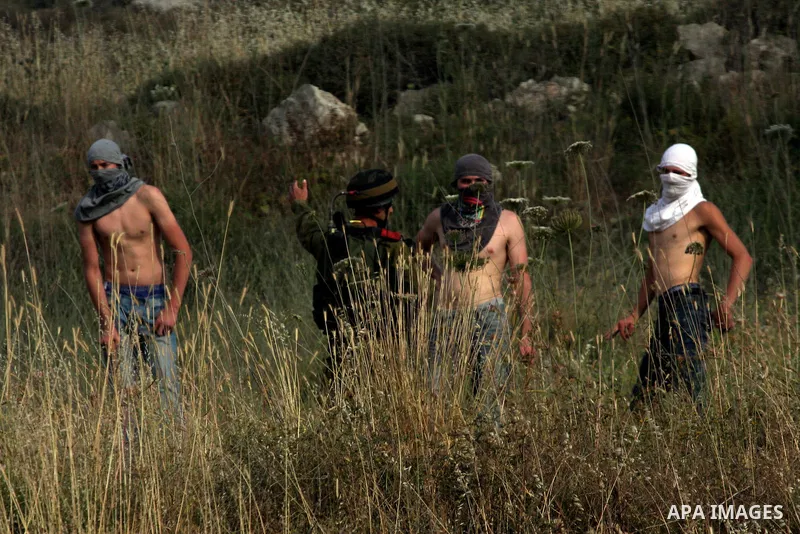 Israeli settlers from the Jewish settlement of Yitzhar throw stones during clashes with Palestinians from the village of Asira al-Qibiliya, south of the northern West Bank city of Nablus on May 19, 2012. The Israeli army...