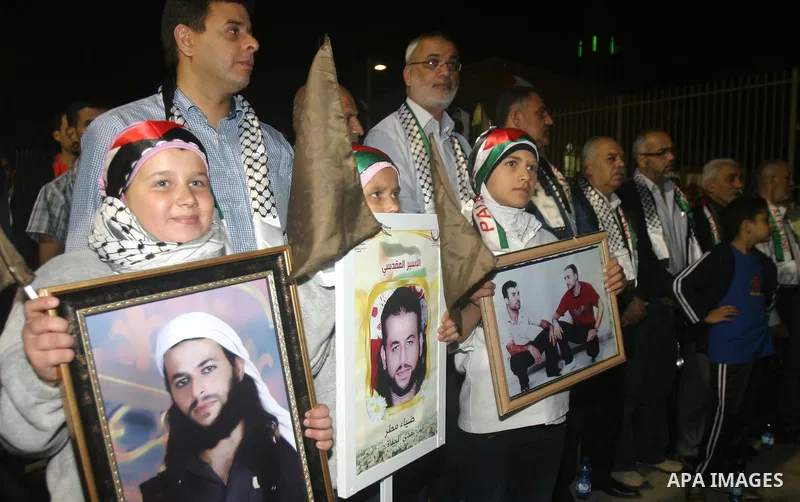 Families of Palestinian prisoners hold pictures of relatives held in an Israeli jail during tourist trip in the West Bank city of Jaffa, on May 19 2012. Photo by Mahfouz Abu Turk