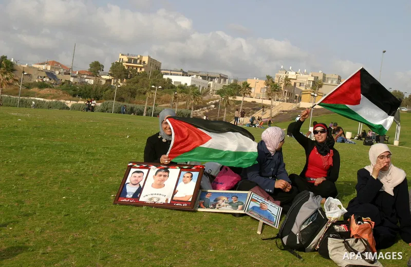 Families of Palestinian prisoners hold pictures of relatives held in an Israeli jail during tourist trip in the West Bank city of Jaffa, on May 19 2012. Photo by Mahfouz Abu Turk