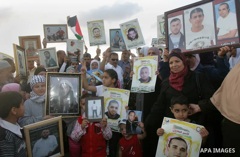Families of Palestinian prisoners hold pictures of relatives held in an Israeli jail during tourist trip in the West Bank city of Jaffa, on May 19 2012. Photo by Mahfouz Abu Turk