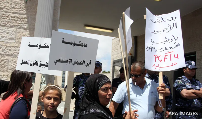 Hundreds of Palestinian workers, hold a banners during a demonstration in front of prime minister Salam Fayyad's offices for the fixing of a minimum wage, and against corruption, prohibitively high prices and the lack of...