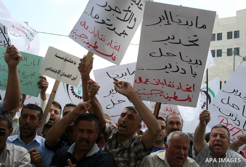 Hundreds of Palestinian workers, hold a banners during a demonstration in front of prime minister Salam Fayyad's offices for the fixing of a minimum wage, and against corruption, prohibitively high prices and the lack of...
