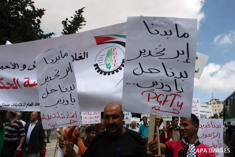 Hundreds of Palestinian workers, hold a banners during a demonstration in front of prime minister Salam Fayyad's offices for the fixing of a minimum wage, and against corruption, prohibitively high prices and the lack of...
