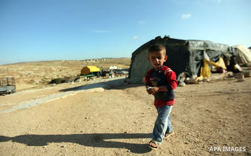 Son of Palestinian Mohammed Nawaj'a plays in the front of project to generate alternative energy, near Jewish settlement of Susiya, in southern Hebron Khirbet Susiya, the West Bank on May 20, 2012. This projects was supp...
