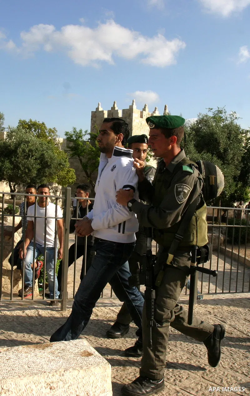 Israeli policemen detain a Palestinian demonstrator protesting against a parade marking Jerusalem Day in front of Damascus Gate outside Jerusalem's Old City on May 20, 2012. Israel occupied East Jerusalem in the 1967 Mid...