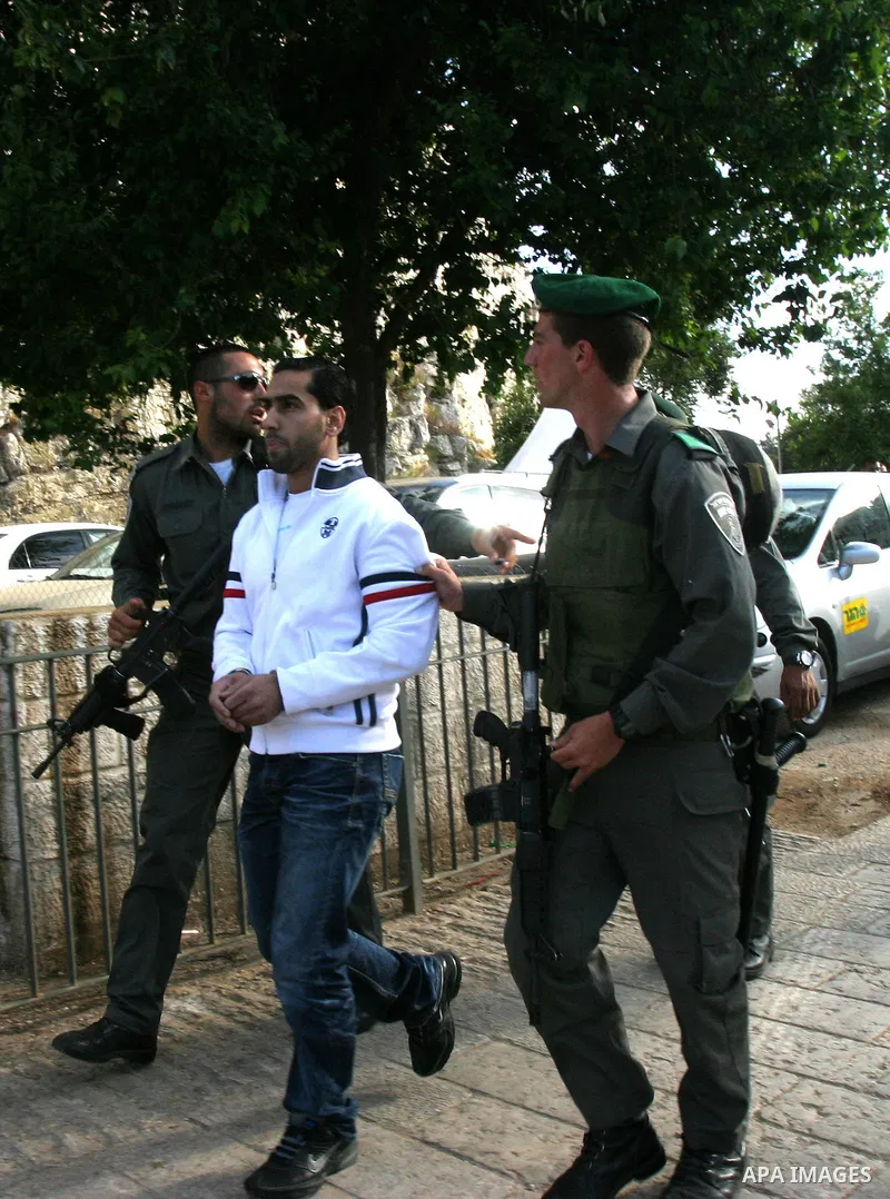 Israeli policemen detain a Palestinian demonstrator protesting against a parade marking Jerusalem Day in front of Damascus Gate outside Jerusalem's Old City on May 20, 2012. Israel occupied East Jerusalem in the 1967 Mid...
