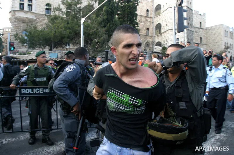 Israeli policemen detain a Palestinian demonstrator protesting against a parade marking Jerusalem Day in front of Damascus Gate outside Jerusalem's Old City on May 20, 2012. Israel occupied East Jerusalem in the 1967 Mid...