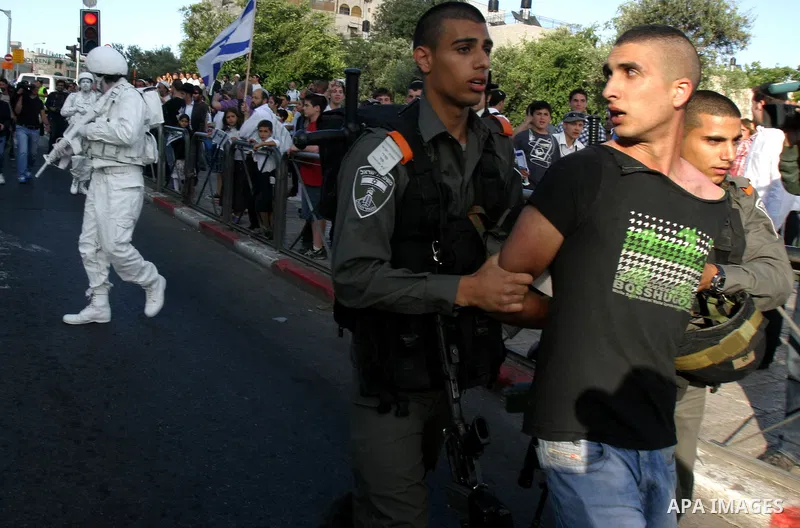 Israeli policemen detain a Palestinian demonstrator protesting against a parade marking Jerusalem Day in front of Damascus Gate outside Jerusalem's Old City on May 20, 2012. Israel occupied East Jerusalem in the 1967 Mid...