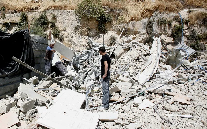Palestinians survey the damage their house into the Jerusalem's old city on May 20, 2012. Thousands of Israelis marched into Jerusalem's old city to celebrate Jerusalem Day when the Jewish state captured the Arab eastern...